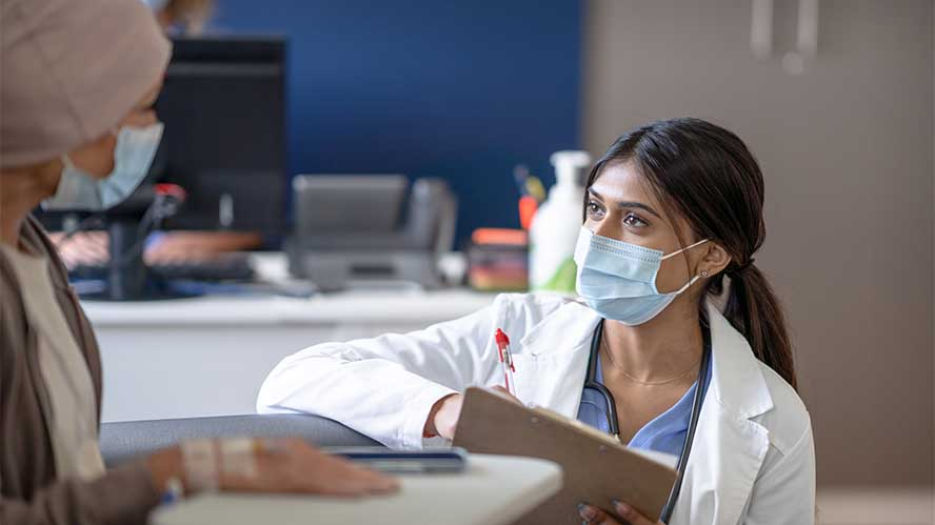 medical professional talks to a patient being treated for cancer